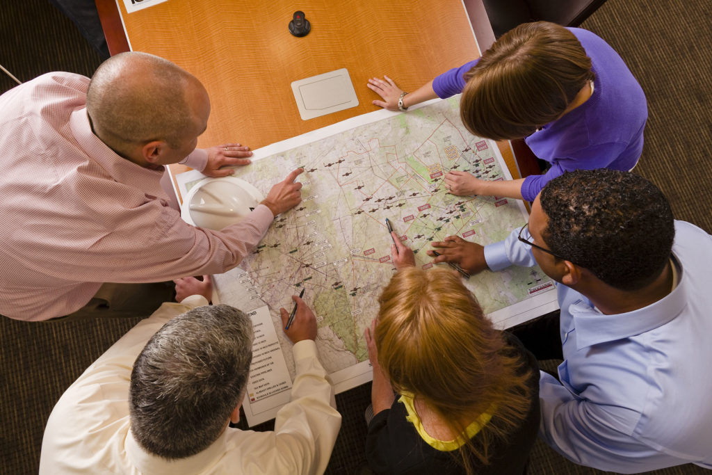 group of people at business meeting working over a map
